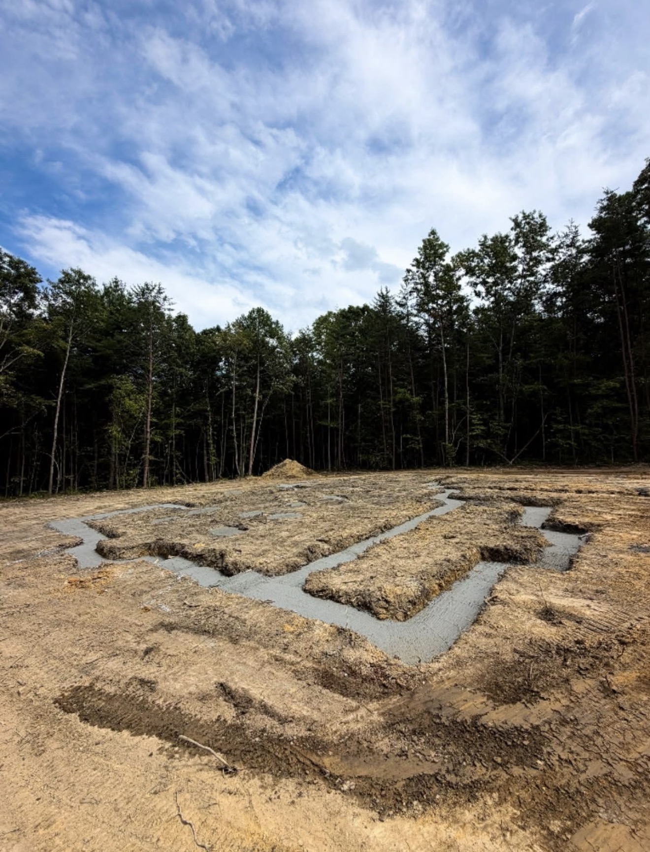 Excavated foundation footings prepared on a wooded building site