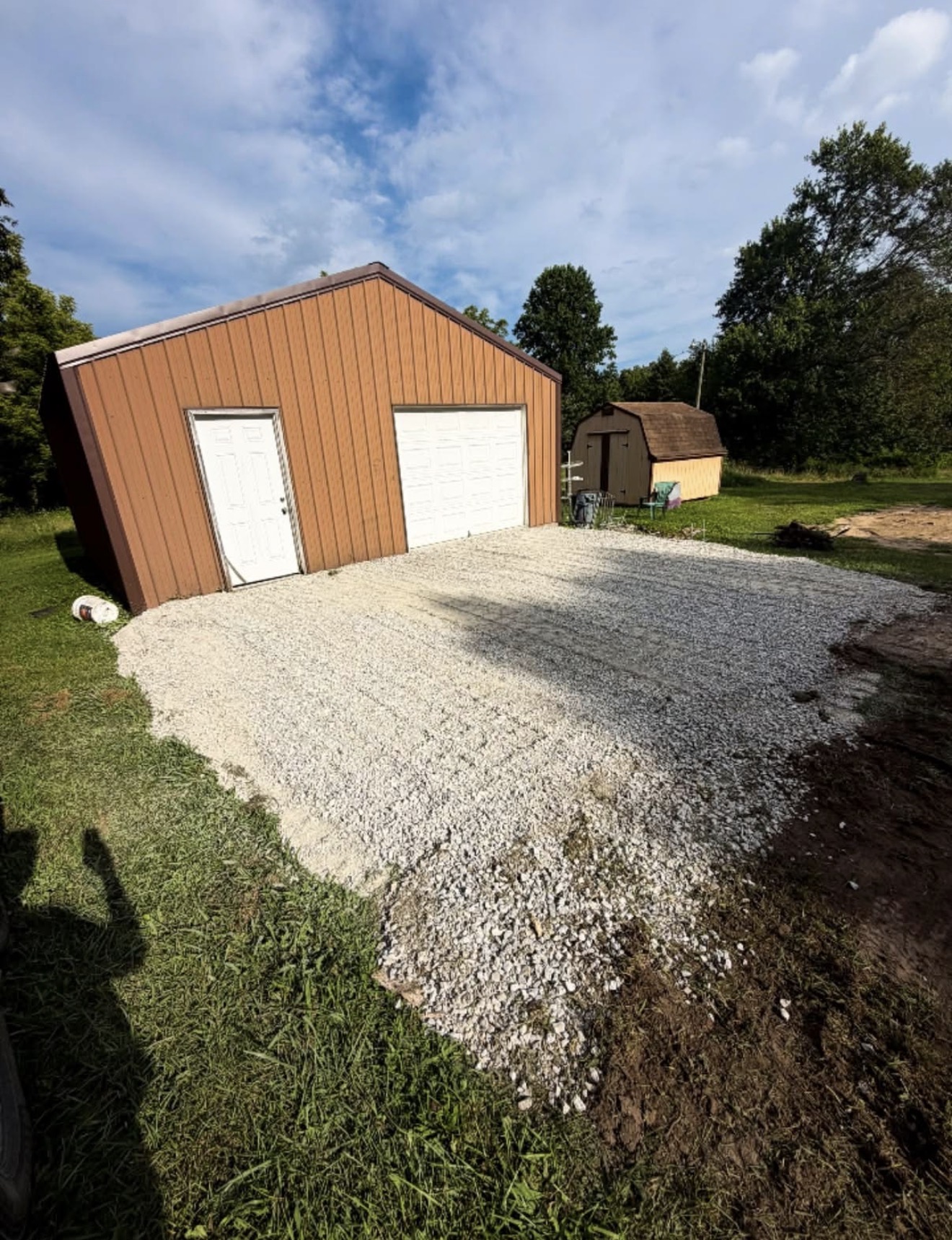 Finished gravel building pad in front of a workshop